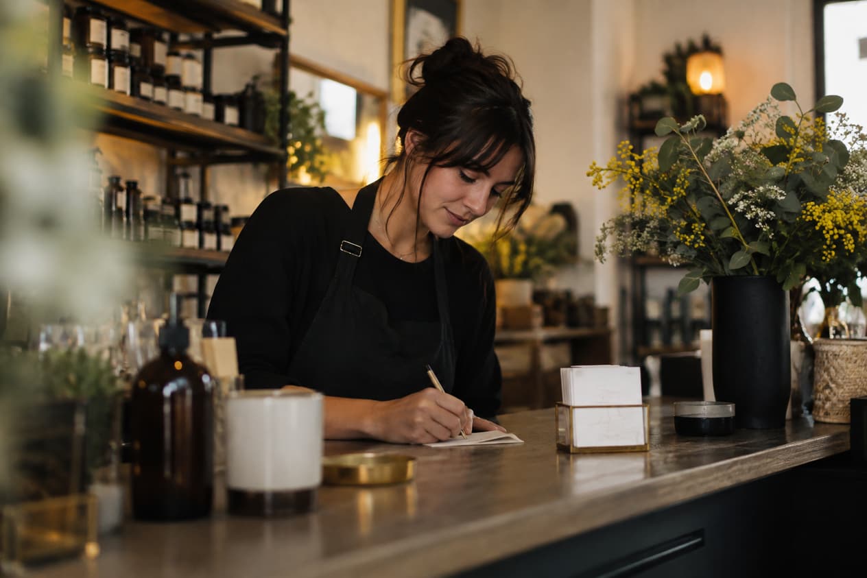 Commerçant écrivant derrière son comptoir