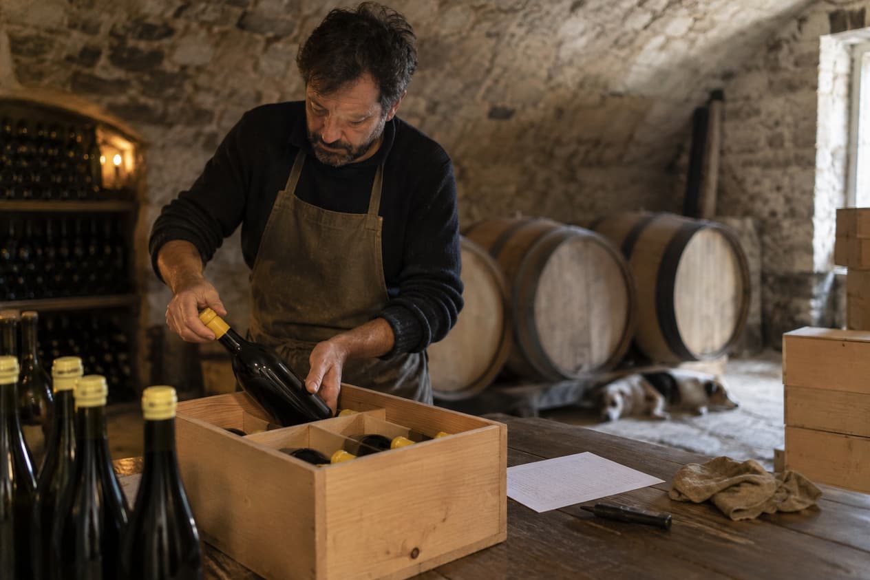 Vigneron jurassien préparant une caisse de bouteilles en cave