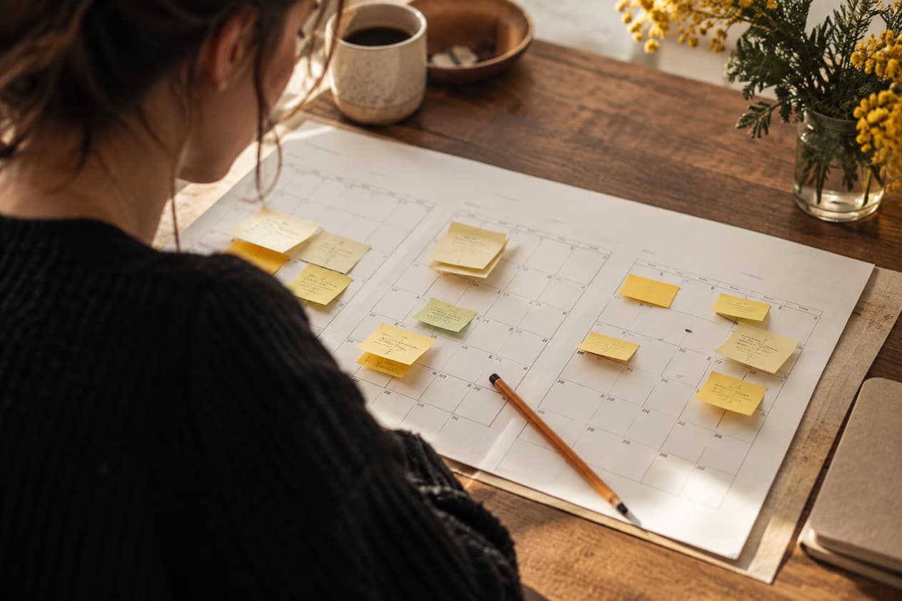 Un calendrier papier de trois mois couvert de notes de couleur